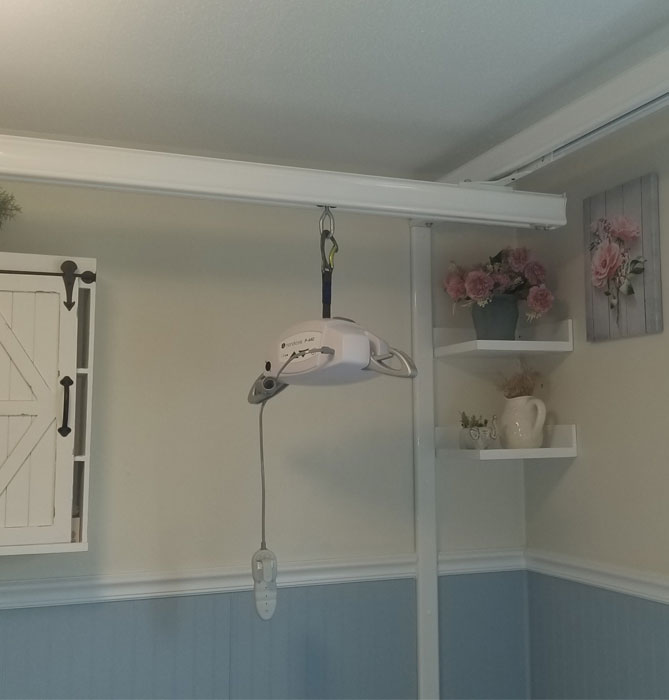 A portable ceiling lift has long legs that extend around the wheelchair or under the bed. It is operated either with a hydraulic lift or a battery powered lift.